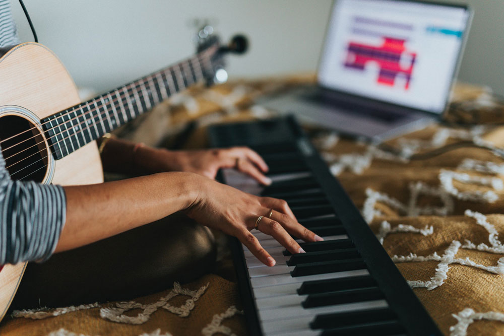 Digital Entrepreneur recording a song with a piano and guitar.